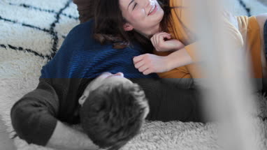 Couple lying down on rug in new home