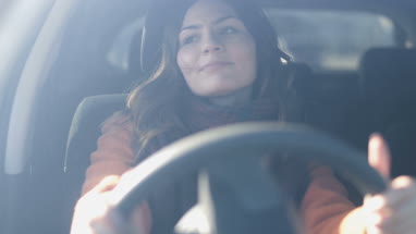 Woman driving car listening to music