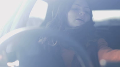 Woman driving car listening to music