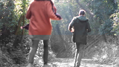 Couple running in forest in Fall