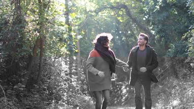 Couple running in forest in Fall