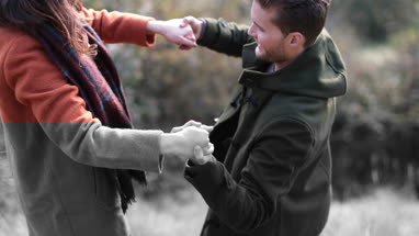 Boyfriend helping girlfriend up in countryside
