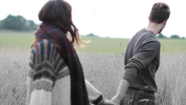 Couple walking in cornfield in fall