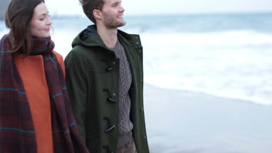 Couple walking on beach in Winter