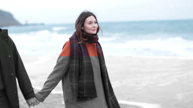 Couple walking on beach in Winter