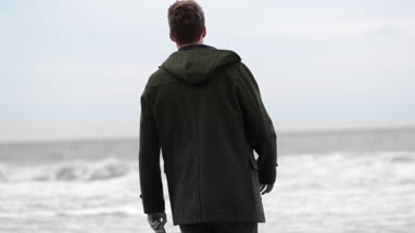 Man throwing driftwood out to sea