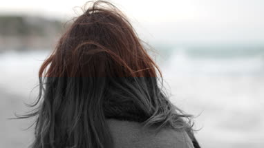 Woman looking to camera on beach in winter
