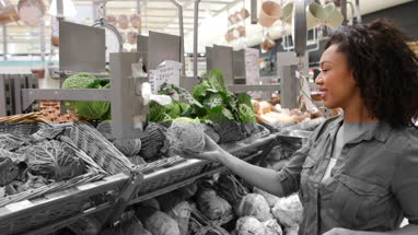 Woman buying vegetables in grocery store