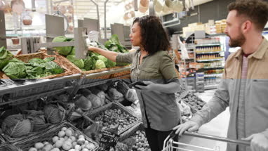 Couple buying vegetables in grocery store