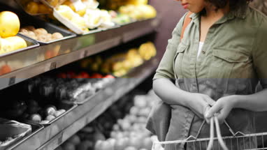 Woman buying fruit and vegetables in grocery store