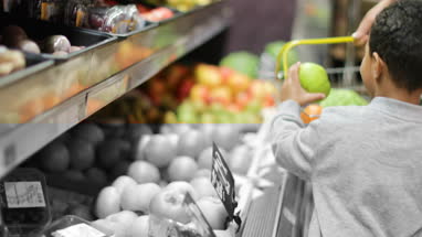 Mother and son buying fruit and vegetables in grocery store