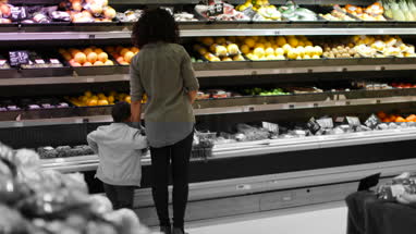 Mother and son buying fruit and vegetables in grocery store