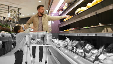 Father and son buying fruit and vegetable in grocery store