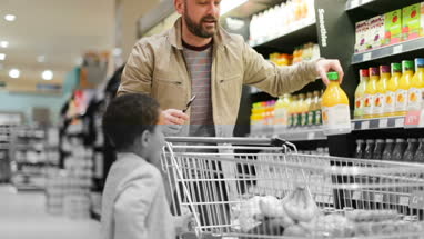Father and son doing weekly shop in grocery store