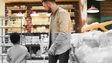 Father and son buying bread in grocery store