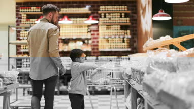 Father and son buying bread in grocery store