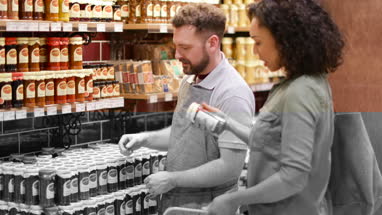 Grocer advising customer in store