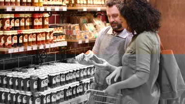 Grocer advising customer in store on ingredients