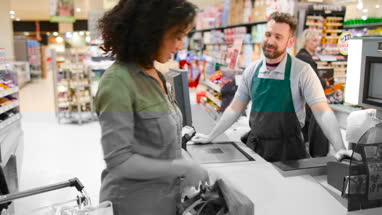 Woman paying for groceries at till