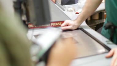 Close-up woman paying for groceries at till