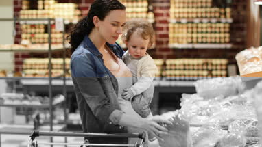 Mother and daughter buying bread in grocery store