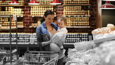 Mother and daughter buying bread in grocery store