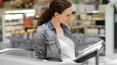 Woman looking at ready meal in grocery store