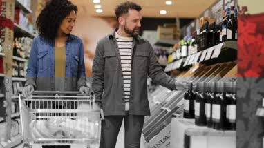 Couple choosing wine in grocery store