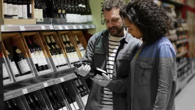 Couple choosing wine in grocery store