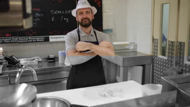 Fishmonger in store looking to camera