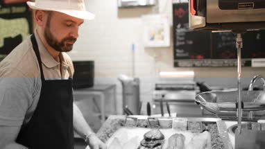 Fishmonger in store arranging fish counter