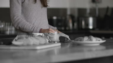 Young adult female having breakfast and checking smartphone