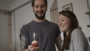 Boyfriend giving girlfriend a birthday cupcake