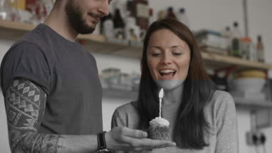 Boyfriend giving girlfriend a birthday cupcake