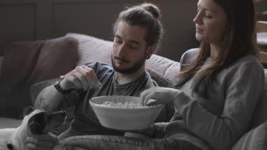 Puppy looking at bowl of popcorn