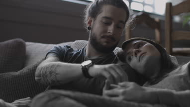 Young couple eating popcorn and watching home movie
