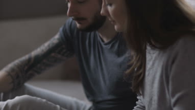 Young couple eating takeout pizza at home