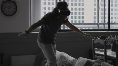 Young adult male learning to surf with VR headset