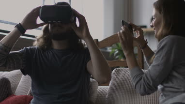 Girlfriend videoing boyfriend using VR headset