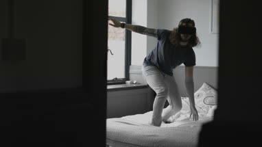 Young adult male learning to surf with VR headset