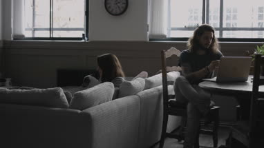 Young female cuddling puppy at home