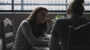 Young adult couple in a caf� together looking at a smartphone