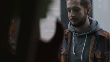 Young adult male looking at guitar through window