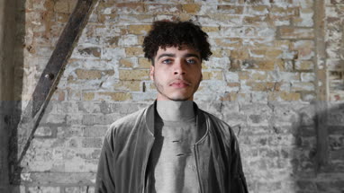 Multiracial young adult male turning to look at camera