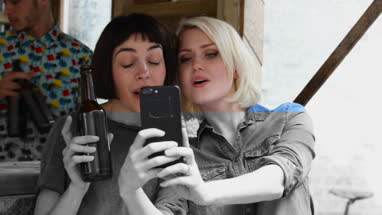 Two friends at a street food bar taking selfie