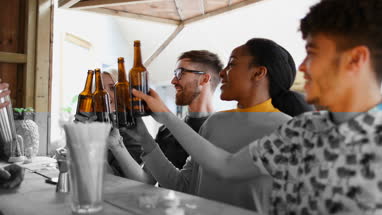 Group of friends at a street food bar saying cheers with beer