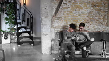 Two male friends looking at a smartphone