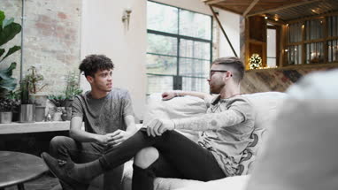 Two male friends relaxing at home