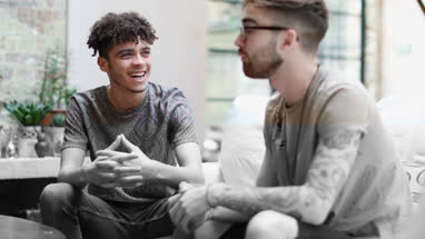Two male friends relaxing at home