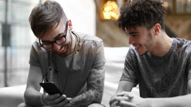 Two male friends looking at a smartphone